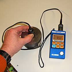 the PCE-TG100 material thickness meter measuring a steel plate