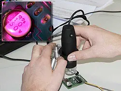 as UV-USB-Mikroskop PCE-MM 200UV bei der Betrachtung einer Platine