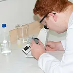 Laborant aan het werk met de Abbe-Refractometer