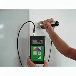 Detector de humedad de madera realizando una medición en una pared