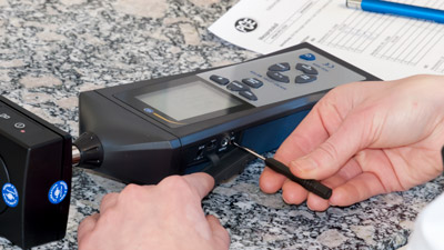 Adjustment on a sound level meter in a calibration laboratory.