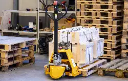 Hand pallet truck with scales in use in the shipping warehouse.