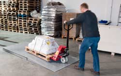 Usando una balanza de plataforma de PCE Instruments para pesar una mercancía.